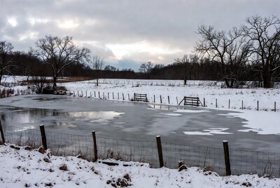 Frozen pond in snowy winter landscape