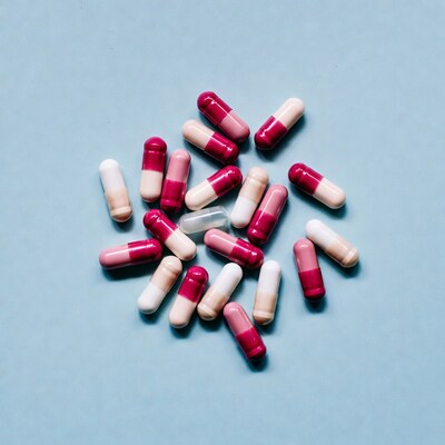 Pink and white capsules on blue background