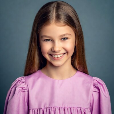 Young girl smiling in purple dress