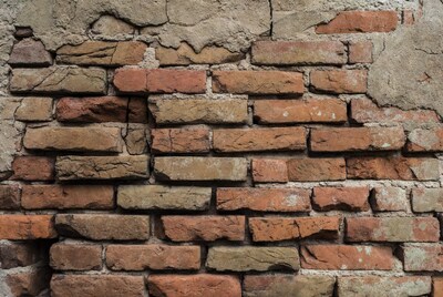 Old brick wall with peeling plaster
