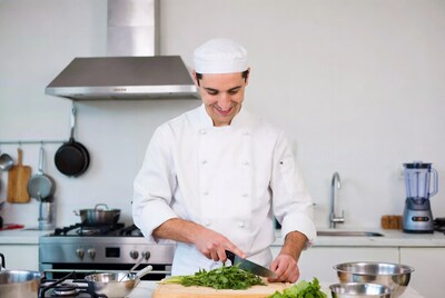 Chef Chopping Herbs in Kitchen