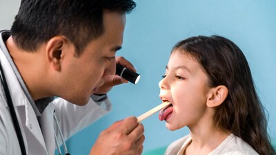 Doctor examining young girl throat