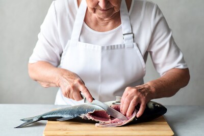 Elderly woman filleting fish