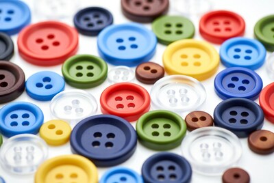 Colorful buttons scattered on white surface