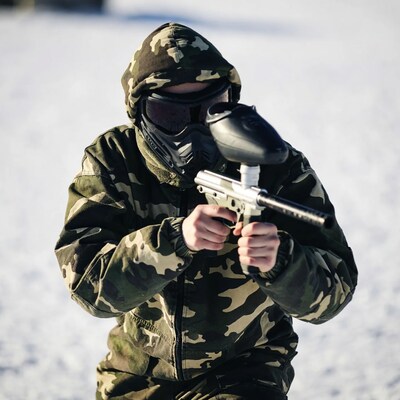 Person in camouflage holding paintball gun