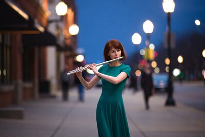Woman playing flute on city street