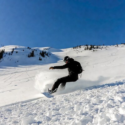 Snowboarder carving on snowy slope
