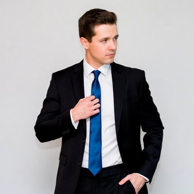 Young man in suit adjusting tie