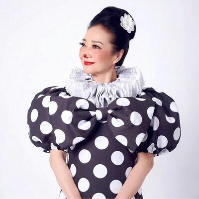 Asian woman in polka dot clown costume