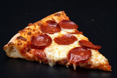 Pepperoni pizza slice on black background