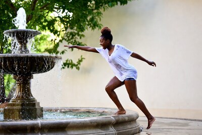 Woman dancing near fountain