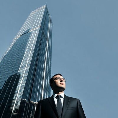 Man in suit looking at skyscraper