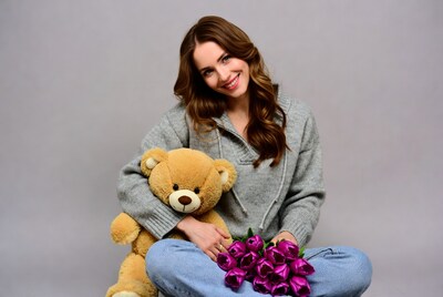 Woman with teddy bear and flowers