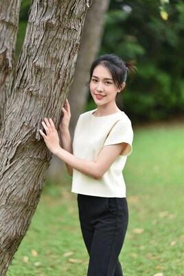 Asian woman leaning on tree