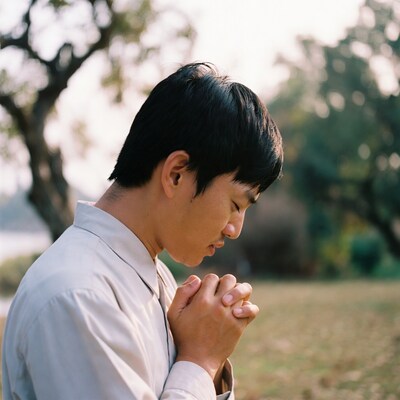 Asian man praying outdoors