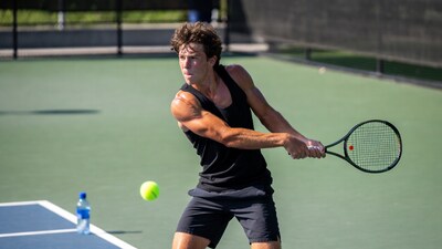 Man swinging tennis racket on court