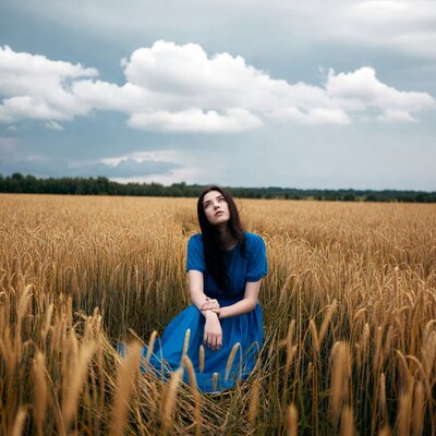 Woman in blue dress in wheat field