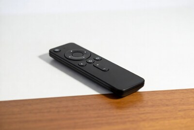 Black remote control on wooden table