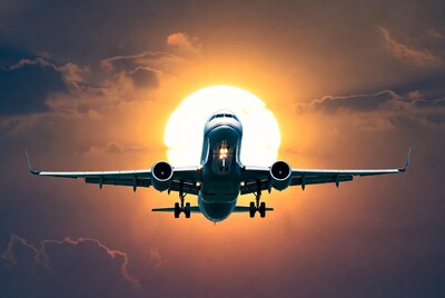 Airplane flying towards sunset