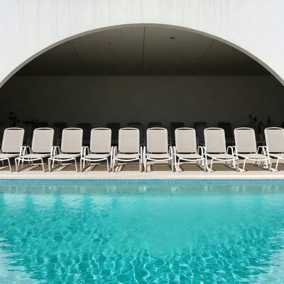 Empty pool chairs by water
