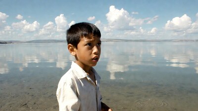 Young boy standing by water