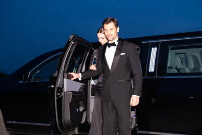Man and woman by luxury car