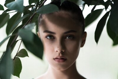 Woman with green eyes behind leaves