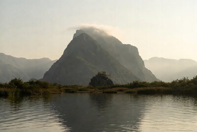 Mountain peak with clouds over lake