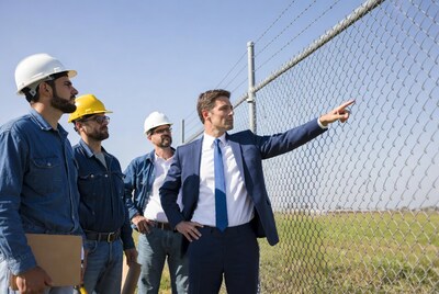Businessman pointing at fence
