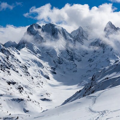 Snowy mountain peaks under clouds