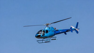 Blue helicopter flying in sky