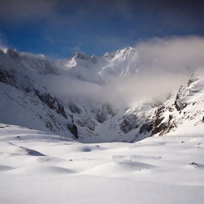 Snowy mountain peaks with clouds