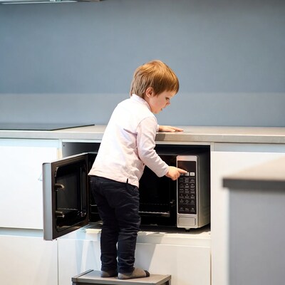 Toddler boy using microwave