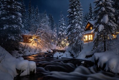 Snowy cabins by winter river