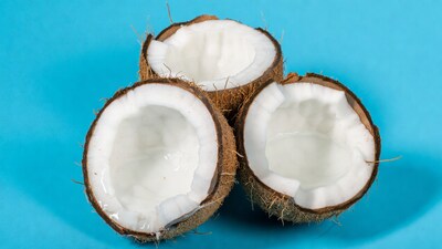 Halved coconuts on blue background