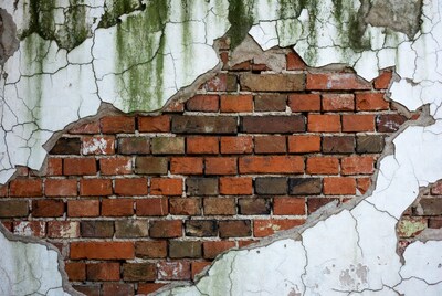 Weathered brick wall with peeling paint
