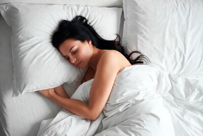 Woman sleeping in white bed