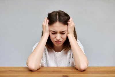 Woman holding head in distress