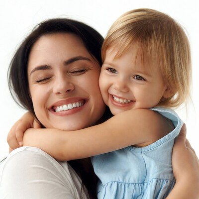 Mother hugging smiling daughter