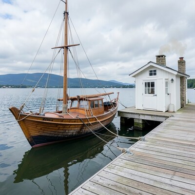Wooden Sailboat Docked at Lakeside Pier