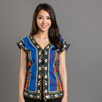 Smiling Asian woman in blue embroidered top