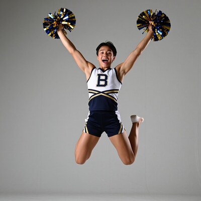 Asian male cheerleader jumping