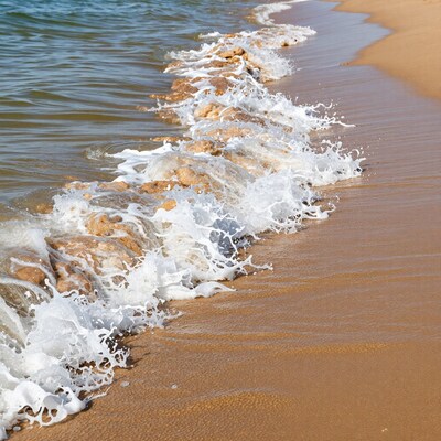 Ocean waves crashing on sandy beach
