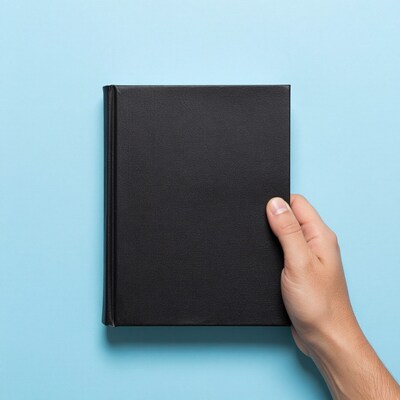 Hand holding black book