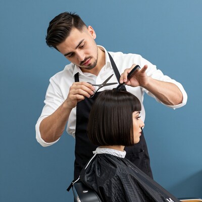 Male hairstylist cutting woman's bob haircut