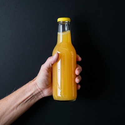 Hand holding orange juice bottle