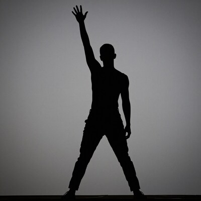 Silhouette man raising hand