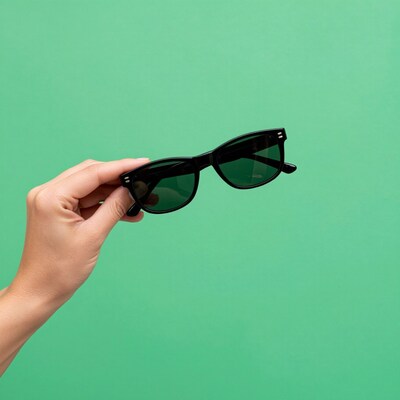 Hand holding black sunglasses