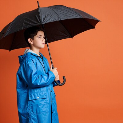 Boy in blue raincoat with umbrella