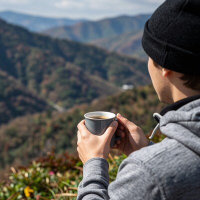 Man drinking coffee mountain view